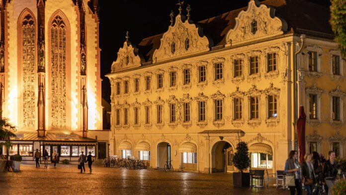Das barocke Falkenhaus am Würzburger Marktplatz am Abend, links die beleuchtete Marienkapelle